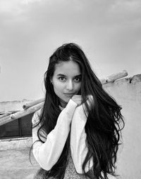 Portrait of young woman standing against sky