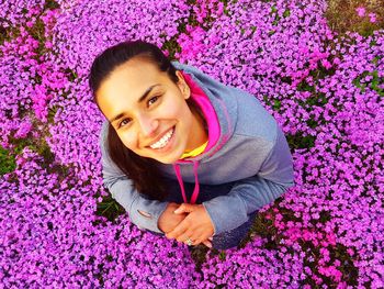 Portrait of smiling woman standing amidst purple flowers