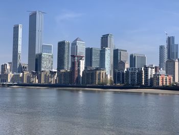 Sea by buildings against sky in city