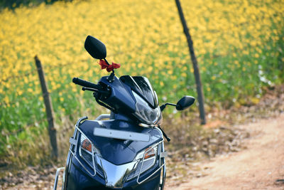 Close-up of motor scooter on field