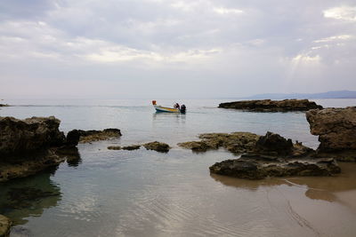 Scenic view of rocks in sea against sky
