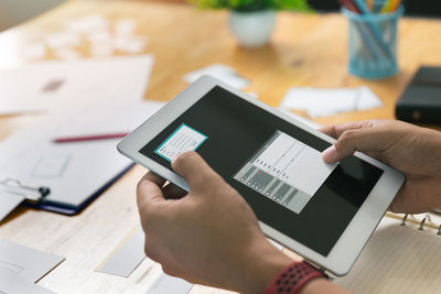 Low section of person using smart phone on table