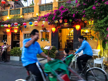 People riding bicycle on street in city