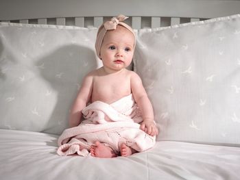 Cute baby girl lying on bed