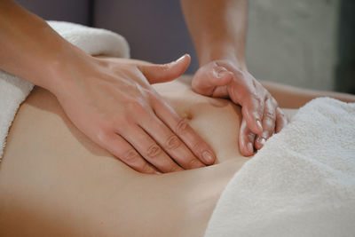 Top view of hands massaging female abdomen. therapist applying pressure on belly. woman receiving