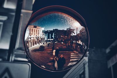 Close-up of glass window against buildings in city