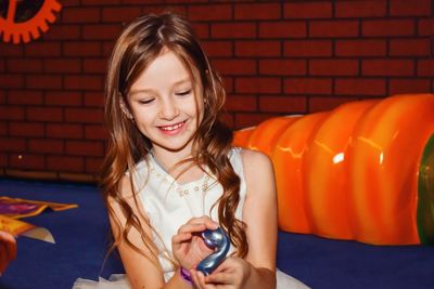 Portrait of smiling girl holding indoors