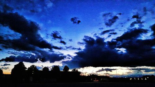 Silhouette trees against sky at night
