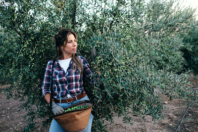 Portrait of woman standing against plants