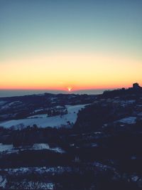 Silhouette cityscape against sky during sunset