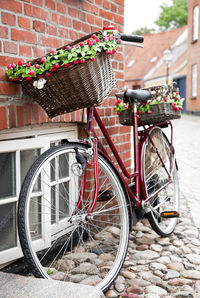 Bicycle parked by street against building
