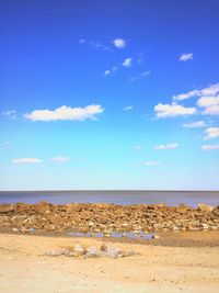 Scenic view of beach against blue sky