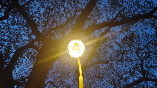 Low angle view of illuminated street light against sky