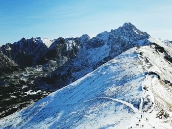  snowcapped mountains and people on hiking trail 