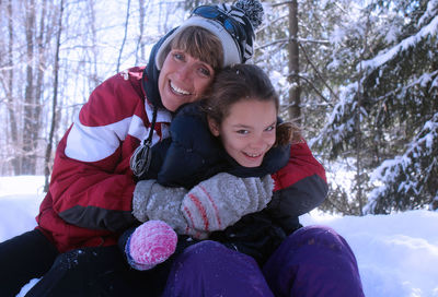 Portrait of mother and daughter in snow during winter