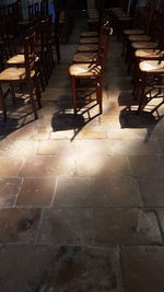 Empty chairs and tables in tiled floor