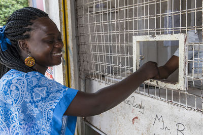 Smiling woman standing by metal structure