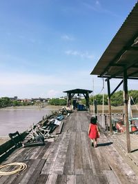 Rear view of woman on bridge against sky