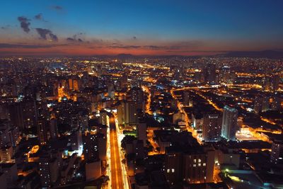 Illuminated cityscape against sky at night