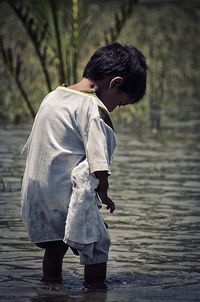 Full length of boy standing on water 