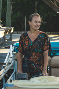 Smiling woman looking away while standing in boat