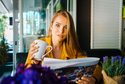 Portrait of young woman sitting outdoors