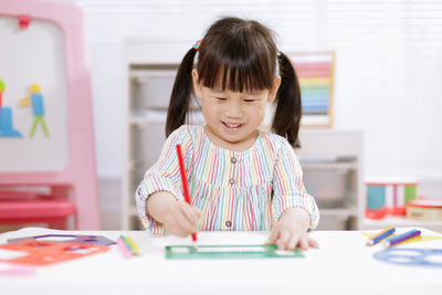 Young girl practice drawing different shapes for home schooling