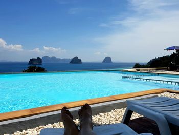 Low section of person relaxing in swimming pool