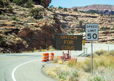 Information sign on road by mountains