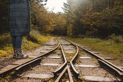 Low section of person standing on railroad track