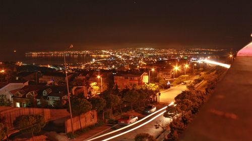 Illuminated cityscape against sky at night