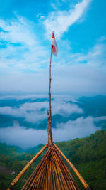 Panoramic view of flag on mountain against sky