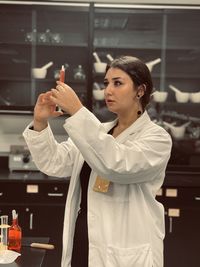 Portrait of young woman standing in laboratory