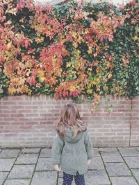 Full length of woman standing on footpath during autumn