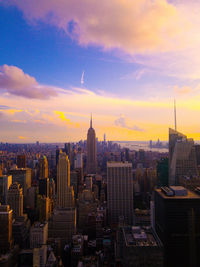 Buildings in city against cloudy sky