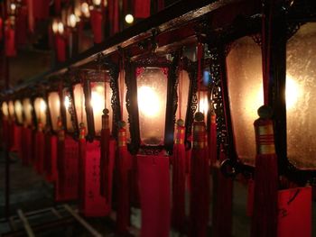 Illuminated lanterns hanging in row at night