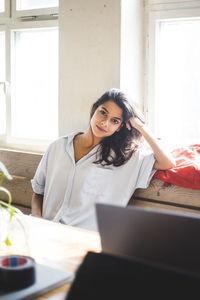 Portrait of young female computer programmer sitting in creative office