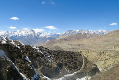 Scenic view of snowcapped mountains against blue sky