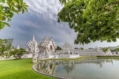 Built structure in lake against cloudy sky