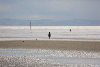 People on beach against sky