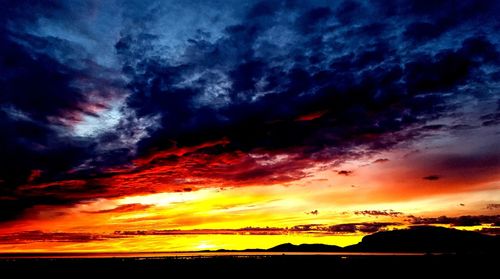 Scenic view of dramatic sky over silhouette landscape