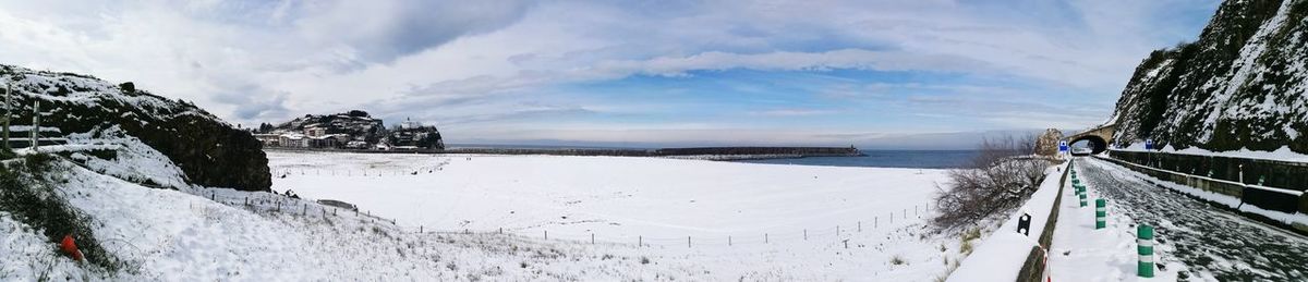 Panoramic view of snow covered landscape against sky