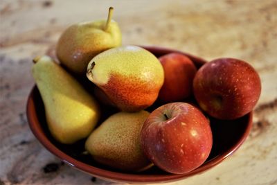 High angle view of apples and pears in bowl on table