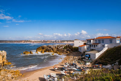 Scenic view of beach by sea against blue sky