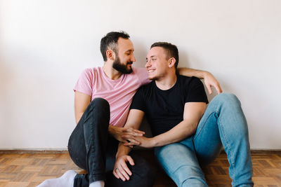 Gay couple laughing in their apartment.