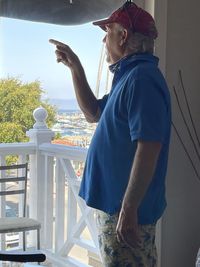 Side view of man standing by railing