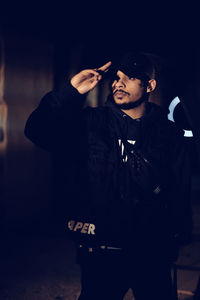 Young man smoking cigarette at night