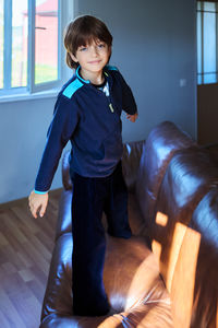 Portrait of boy sitting on sofa at home