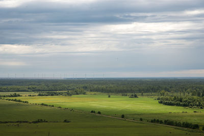 Scenic view of grassy field against cloudy sky