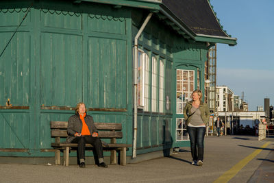 Woman sitting in front of built structure